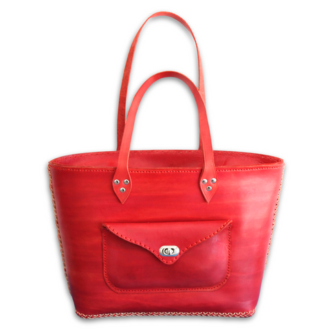 Red Kimbia tote bag made from Argentinian leather featuring an exterior pocket and two straps made by Gy Crafts.