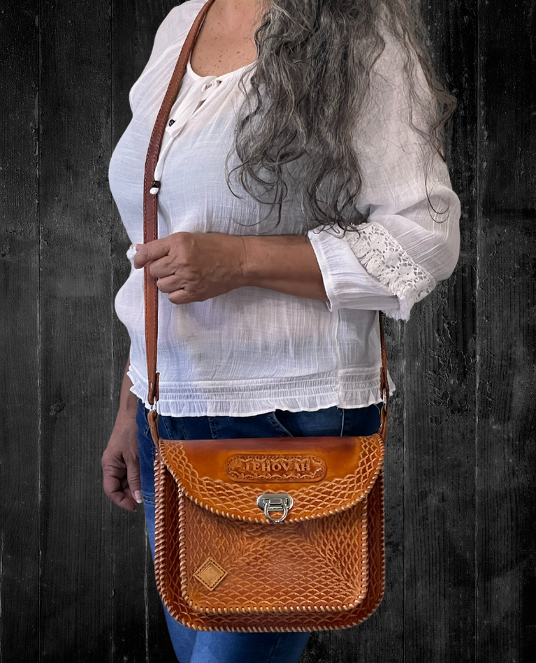 Model displaying a brown Cuyuni bag hanging from a single long strap on her shoulder. Made by Gy Crafts