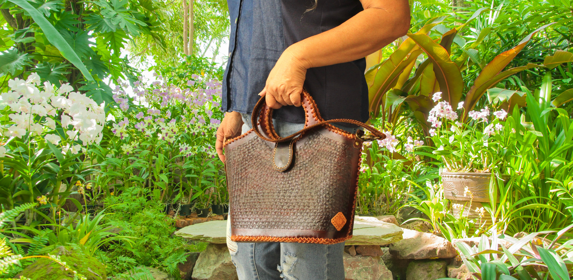 Model displaying brown Puruni wristlet hanging from her hand closer to her wrist. Made by Gy Crafts.