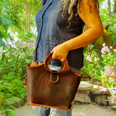 Model holding a Chocolate brown leather Puruni bag made by Gy Crafts.