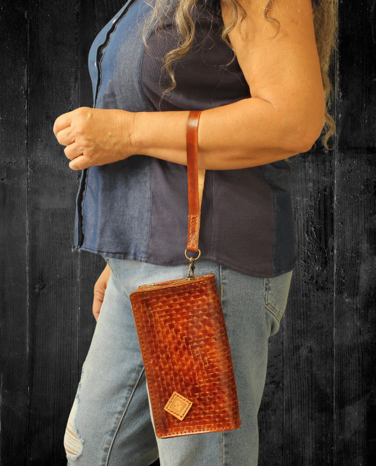 Model displaying brown Puruni wristlet hanging from her hand closer to her wrist. Made by Gy Crafts.