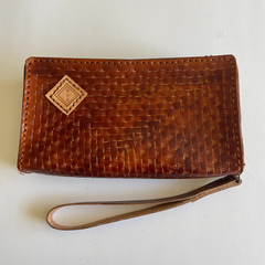 Brown Puruni wristlet made from aged Italian Tuscany leather with a single strap and zip closure. Made by Gy Crafts.