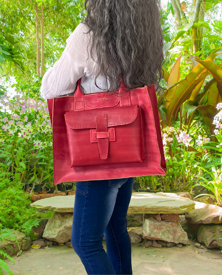 Model displaying red Bohemia bag featuring double shoulder straps, outside pockets and a floating interior. Made by Gy Crafts